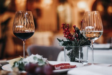 wine glasses and red roses on a wooden table