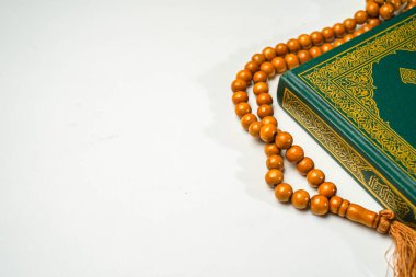 El-Kur 'an' ın Arapça el yazısı ve beyaz arkaplan üzerinde tespih ya da tasbih bulunan beyaz arkaplan..