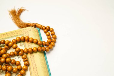 El-Kur 'an' ın Arapça el yazısı ve beyaz arkaplan üzerinde tespih ya da tasbih bulunan beyaz arkaplan..