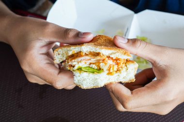 Bir çocuğun elinde hamburger, aç bir çocuk yemeden önce bir çizburger tutuyor, uzayı kopyalıyor.