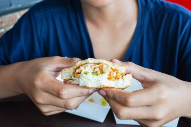 Bir çocuğun elinde hamburger, aç bir çocuk yemeden önce bir çizburger tutuyor, uzayı kopyalıyor.