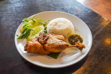 Kızarmış ördek, taze sebze ve kırmızı biber sosuyla servis edilir.