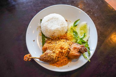 Kızarmış ördek, taze sebze ve kırmızı biber sosuyla servis edilir.