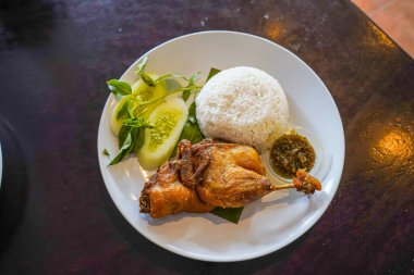 Kızarmış ördek, taze sebze ve kırmızı biber sosuyla servis edilir.