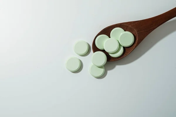 Gyógyszerek Antibiotikumok Csoportja Fehér Orvosi Tabletták Világoszöld Fakanállal Fénymásoló Felülettel — Stock Fotó