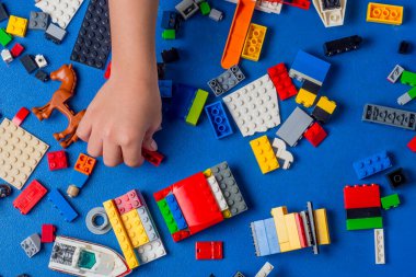 Çocukların erken yaşta öğrenme ve motor gelişimi, renkli plastik tuğlalarla oynayan ve inşa eden çocuk, eğitici yapı kavramı