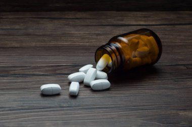 Tahta masaya dökülmüş şişeli ilaç tableti. 