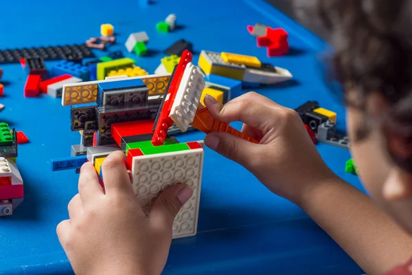 Çocukların erken yaşta öğrenme ve motor gelişimi, renkli plastik tuğlalarla oynayan ve inşa eden çocuk, eğitici yapı kavramı