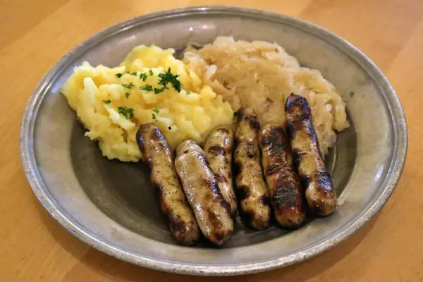 stock image German cuisine: bratwurst (grilled pork sausages), mashed potatoes and sauerkraut (sour cabbage) in Nuremberg, Germany