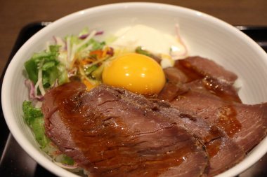 Japanese cuisine: ostrich meat bowl with raw egg in Tokyo, Japan clipart