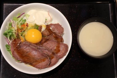 Japanese cuisine: ostrich meat bowl with raw egg in Tokyo, Japan clipart