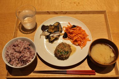 Japanese cuisine set meal: jikkokumai, miso soup, hamburg steak with renkon (lotus root) sauce, shimesaba (vinegared mackerel) with eggplant and carottes rpes (grated carrot salad) in Tokyo, Japan clipart