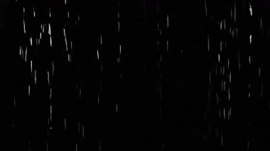Siyah ekrana karşı kameranın önüne şiddetli yağmur yağıyor. Yağmur damlaları damlıyor. Yakın çekim vfx ekleyin. Pratik kusursuz döngü görüntüsü
