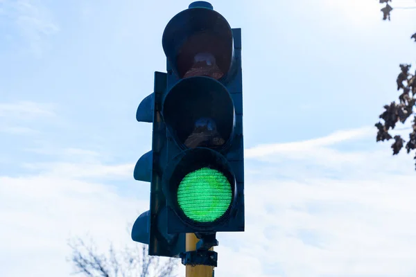 traffic light with the green light on with a blue sky background