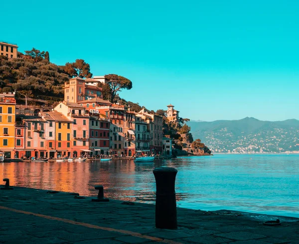 Günbatımında Portofino Körfezi panoraması, resimli renkli evleri ve tekneli huzurlu mavi denizi
