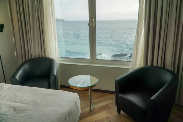 Scenic view of a hotel room with a window overlooking the mesmerizing ocean, offering a tranquil and luxurious seaside escape.