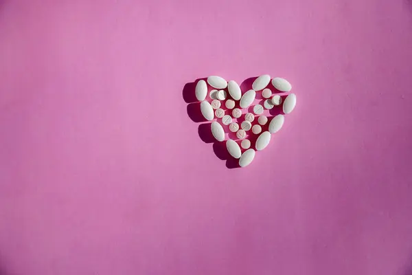 Uno Sfondo Rosa Con Una Pillola Medicinale Forma Cuore Che — Foto Stock
