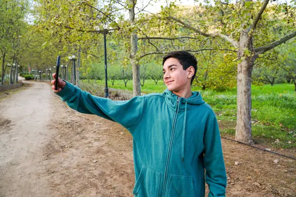 10代の少年が携帯電話で写真を撮ってソーシャルメディアに投稿する インフルエンサー — ストック写真