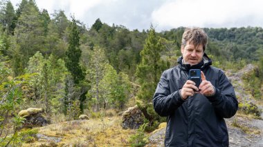 Bir baba, bir gezi sırasında grubun fotoğrafını çekmek için telefon kamerasına nişan alır..