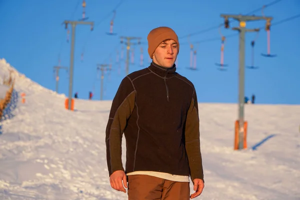 スキーの長い一日後に雪の中の若い男 ロイヤリティフリーのストック画像