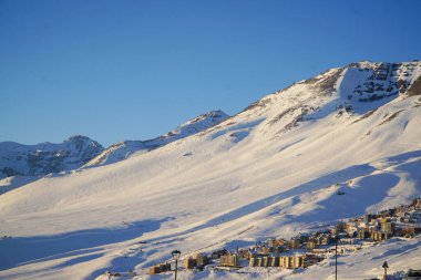 Karlı dağın ortasında bir kayak merkezi manzarası. 
