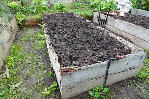 Stock image wooden bed prepared for autumn cultivation. vegetable garden soil ready for planting crops.