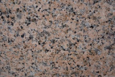 Benekli granit yüzeyin detaylı görüntüsü bej, siyah ve gri tonların karışımı..