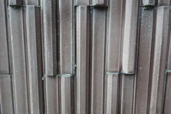 stock image Detailed close-up of a brown wall featuring a geometric, ridged pattern in vertical lines.