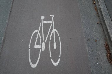 Asfalt bisiklet şeridine çizilmiş beyaz bir bisiklet sembolü belirlenmiş bir bisiklet yolunu gösteriyor..