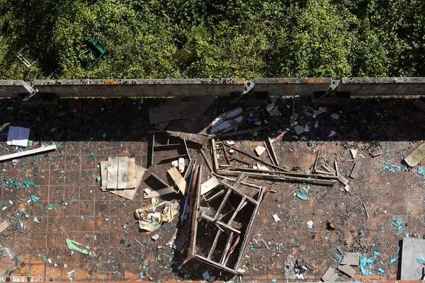 stock image Overhead view of an abandoned school balcony littered with shattered glass, broken furniture, and scattered debris.