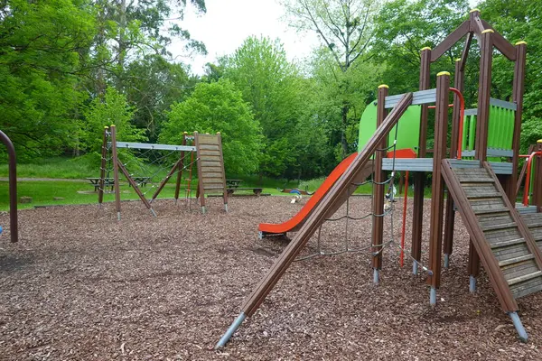 Renkli oyun alanı ekipmanları çocukları parktaki güzel bir günde tırmanmaya, kaymaya ve sallanmaya davet ediyor.