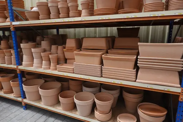 Bahçe merkezindeki raflarda çeşitli terasotta saksıları ve ekiciler düzenlenir. Bahçe meraklılarına satılmaya hazırdır.