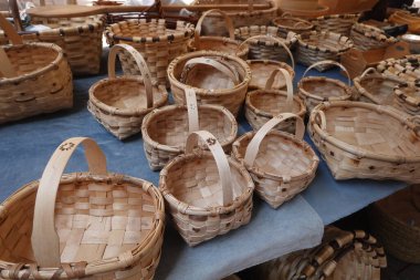 Çeşitli boyutlarda el yapımı hasır sepetler açık hava el sanatları pazarındaki bir masaya yerleştirilmiş geleneksel dokuma tekniklerini sergiliyorlar.
