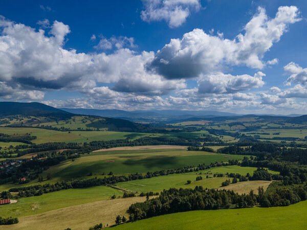 Beautiful aerial view of meadows with forest and Jeseniky in the background. Czech republic.