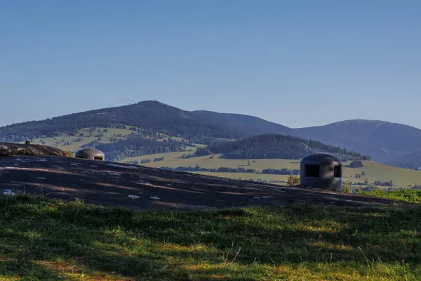 フォアグラウンドの森 牧草地 コンクリートバンカーとチェコの山 ロイヤリティフリーのストック写真