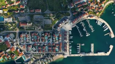Karadağ 'ın Budva Eski Kasabası' nın 4K insansız hava aracı görüntüleri, güneş ışığı ve limanı olan taştan binalar ve güzel mavi deniz suyuyla çevrili yeni bir şehir.