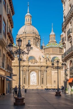 Zaragoza 'nın önemli mimari sembollerinden biri olan del Pilar Bazilikası ve Ebro nehri ve günbatımı renkleri ve bulutlarıyla yansıması.