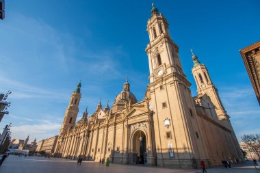 Zaragoza 'nın önemli mimari sembollerinden biri olan del Pilar Bazilikası ve Ebro nehri ve günbatımı renkleri ve bulutlarıyla yansıması.
