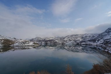 snowy mountains and blue sky with reflection in lake shot in winter season