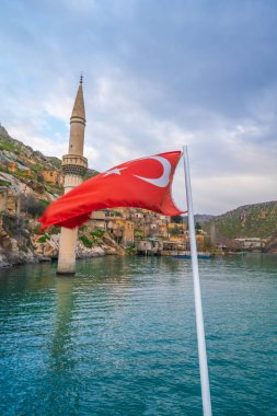 Yarısı köy ve batık minaresi ve Türk turistik tekne bayrakları