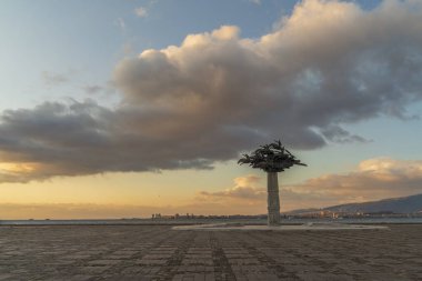 Deniz kenti İzmir sahillerinden gün batımında heykeller ve binalar