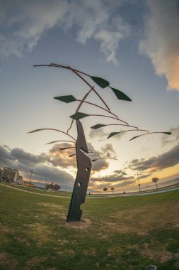 Deniz kenti İzmir sahillerinden gün batımında heykeller ve binalar