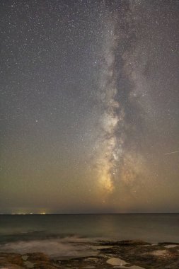 Yıldızlı gece gökyüzü Samanyolu üzerinde okyanusun üzerinde