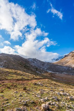 Üzerinde bulutlar olan çorak dağlar.