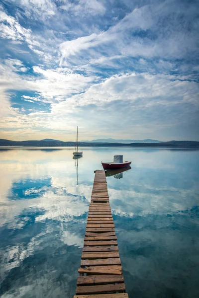 Deniz yansıyan gökyüzü evleri ve tekneler