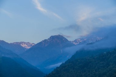 Yeşil dağlık arazideki evler bulutlarla ve dağlarla çevrili harika manzaralar doğada yaşama fikri.