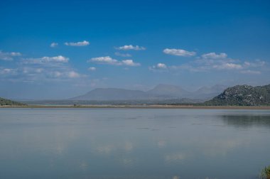 Yansımalı göl manzarası ve yeşil doğa mavi suyu bulutlandırır