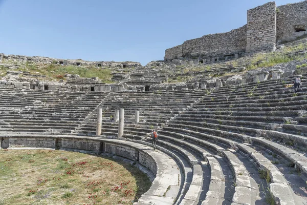 details of ancient settlement milet amphitheater flowers and green nature with blue sky