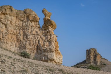 Terkedilmiş doğanın ortasında eşsiz kaya formları. Gün batımı renkleri ve gökyüzünde bulutlar.