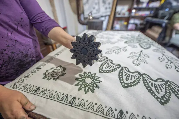 Womans hand working with fabric printing mold and ink traditional writing and woodblock printing work of Kastamonu and Anatolia region.